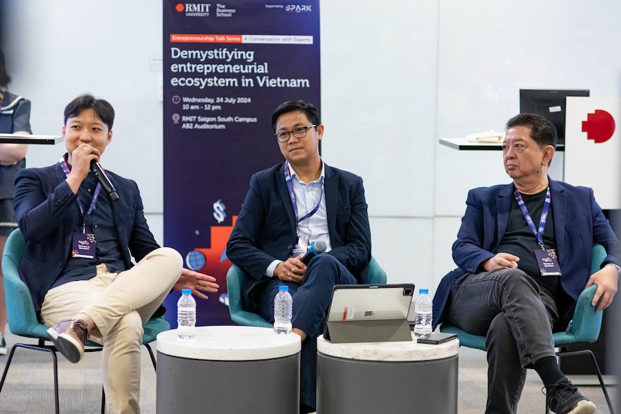 Three industry panellists seated on stage during an RMIT talk